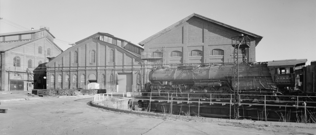 Southern Pacific Sacramento Shops Partial view of turntable, with ATSF 5021, unrestored 2-10-4 steam locomotive, looking south. Erecting/Machine Shop is in background, with Planing Mill partially visible at left. Jet Lowe, photographer.